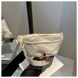 Detail of cream white crossbody chest bag showing high density fabric and woven zipper puller