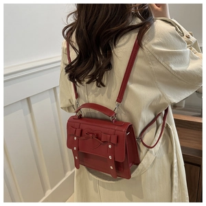 Bolso sobre rojo con corazones usado por modelo en abrigo beige para un look diario chic