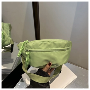 Detail of light green nylon waist bag with woven rope zipper and durable strap buckle