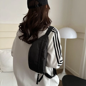 Minimalist black nylon crossbody chest bag with adjustable strap shown on model back