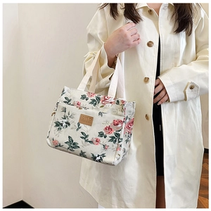 Detalle de la bolsa de almuerzo de lona con estampados florales y parche de cuero