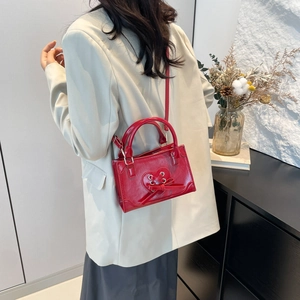 Chic sac à main rouge en cuir verni avec découpe cœur et nœud sur modèle