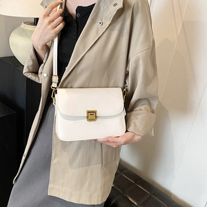 Minimalist white leather square crossbody bag with gold buckle shown on a model