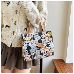 Detalle del bolso de lona con dibujos de gatos lindos y asa tejida marrón resistente