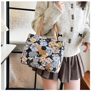 Detalle de la bolsa de almuerzo de lona con lindos gatos impresos y asas de cinta fuertes
