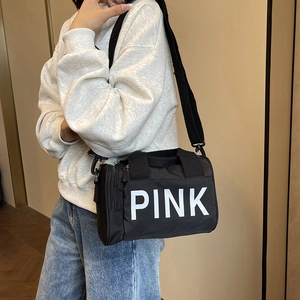 Minimalist black cylinder sports shoulder bag with white PINK lettering and crossbody strap