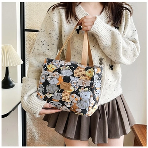 Detalle de bolsa de lona para almuerzo con estampado de gatos y forro térmico aislante