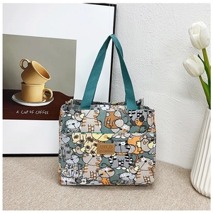 Detalle de la bolsa de almuerzo de lona con lindos estampados de gatos y parche de cuero