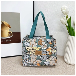 Detalle de bolsa de lona para almuerzo con gatos animados y parche de logo en cuero