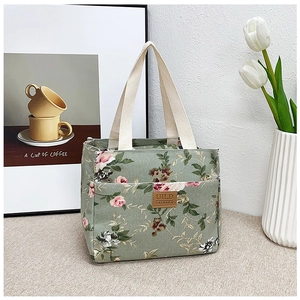 Detalle de la bolsa de almuerzo de lona floral con logo de cuero y asas tejidas