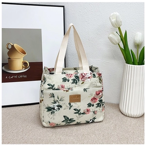 Detalle del bolso de lona con estampado de rosas y etiqueta de cuero vintage