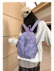 Detail view of purple nylon backpack featuring cartoon bear print and side drawstring cords