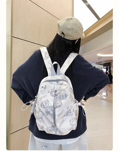 Street style white backpack featuring grey teddy bear prints and side drawstring pockets