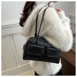 Primer plano de bolso retro negro con bolsillos delanteros dobles y textura de cuero