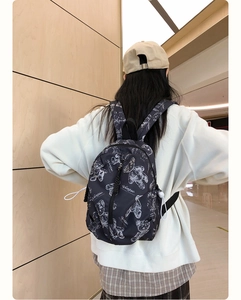 Close-up of black waterproof nylon backpack featuring a white bear print and side drawstring