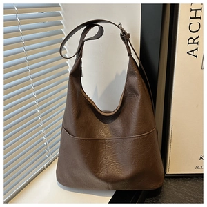 Détail de la texture cuir PU et poche frontale du grand sac à bandoulière style vintage