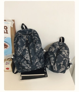 Detail of dark grey backpacks in two sizes with bear prints and front zipper design