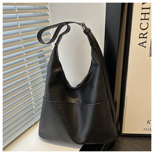 Détail macro du sac hobo noir avec une texture en cuir plissé au style vintage