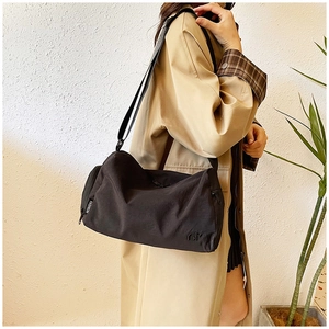 Dettaglio macro della borsa tempo libero in nylon nero con etichetta moda su modella