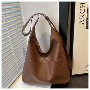 Détail du sac hobo marron vintage montrant la texture grainée et la poche frontale