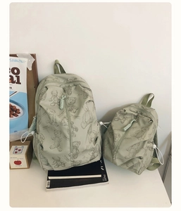 Detail view of light green water-resistant backpacks with vintage teddy bear prints