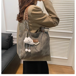 Détail du grand sac cabas gris avec poignées en cuir, chaîne et breloque nuage peluche