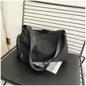 Dettaglio macro della borsa fitness nera in nylon capiente con cerniera laterale e etichetta