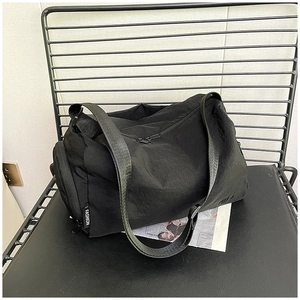 Dettaglio della borsa in nylon nero increspato leggero con scomparto laterale con zip