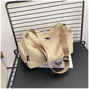 Dettaglio borsa a cuscino in nylon beige con cerniere nere ed etichetta moda esterna