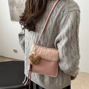Sac seau rose minimaliste en peluche avec breloque ours porté par un mannequin