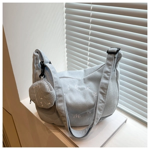 Détail du sac cabas en velours côtelé bleu clair avec broderies et mini porte-monnaie