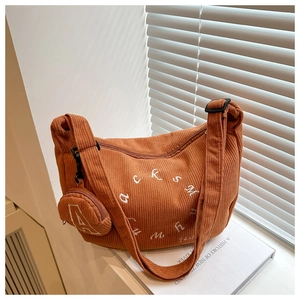 Détail du sac hobo en velours côtelé marron orange avec large bandoulière et petite pochette