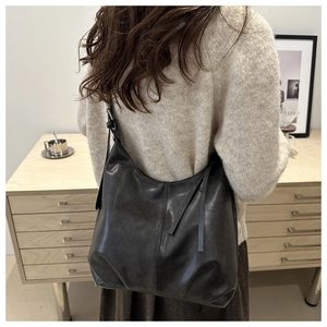 Modell mit großer schwarzer Hobo-Tasche aus mattem Leder und modischem Schultergurt