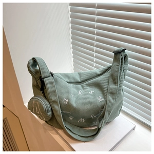 Détail du sac cabas en velours côtelé vert clair avec broderie et petite pochette