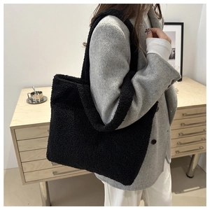 Detail of black faux fur tote bag showing plush texture and large shoulder strap design