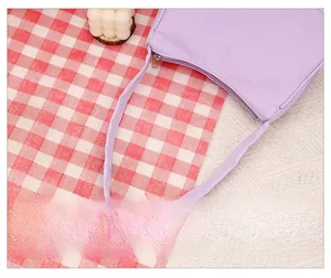 Detail of comfortable purple shoulder strap and silver metal zipper on crescent bag