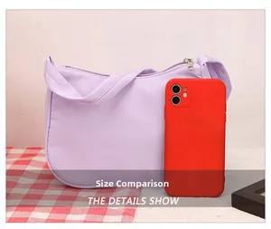 Size comparison of light purple nylon shoulder bag with a red phone against grid fabric