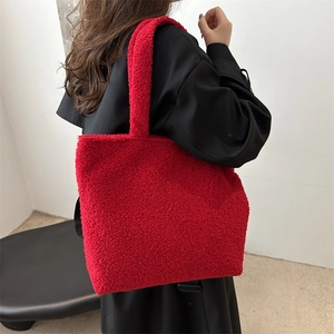 Red teddy wool tote bag for women worn over shoulder with elegant black winter coat