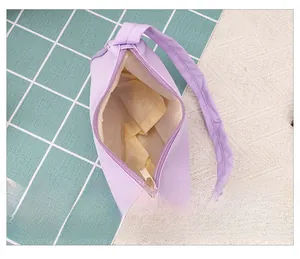Internal view showing purple shoulder bag with beige lining and zip pocket details