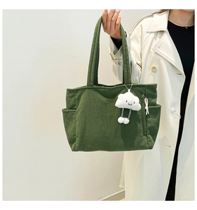 Detailed texture of green corduroy tote bag with cute cloud plush charm accessory