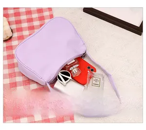 Detail view of the light purple crescent bag interior showing daily essentials and silver zipper