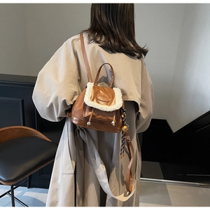 Détail du sac à dos marron et blanc en fausse fourrure porté par le mannequin