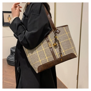 Vue détaillée du sac cabas pour femme à motif pied-de-poule porté à l'épaule dans une pièce