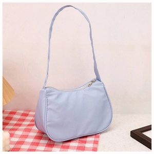 Close-up of light blue crescent underarm bag with silver zipper and long shoulder strap