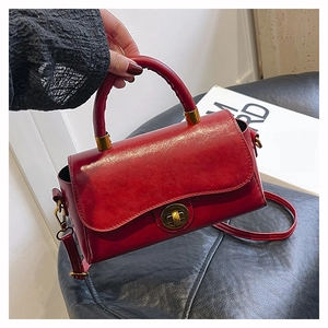Vue détaillée du sac à main en cuir ciré rouge foncé avec fermoir rotatif doré