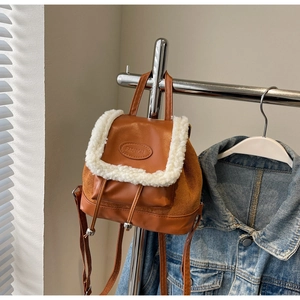Détail d'un mini sac à dos marron en similicuir, suédine et finitions en peau lainée douce