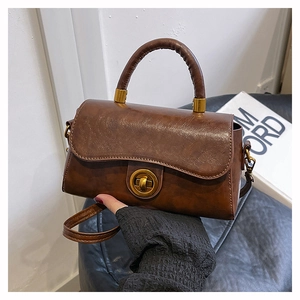 Détail d'un sac à main rétro marron caramel avec fermoir tournant vintage et texture cuir huilé