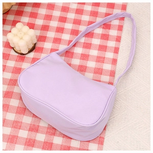 Detail of light purple shoulder bag on a picnic blanket with a modern candle