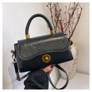 Détail du sac à main rétro noir avec fermoir doré vintage et texture en cuir poli