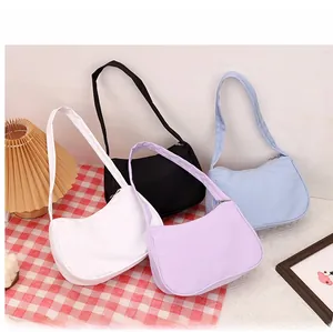 Minimalist nylon crescent bags in white, black, purple, and blue colors on a table